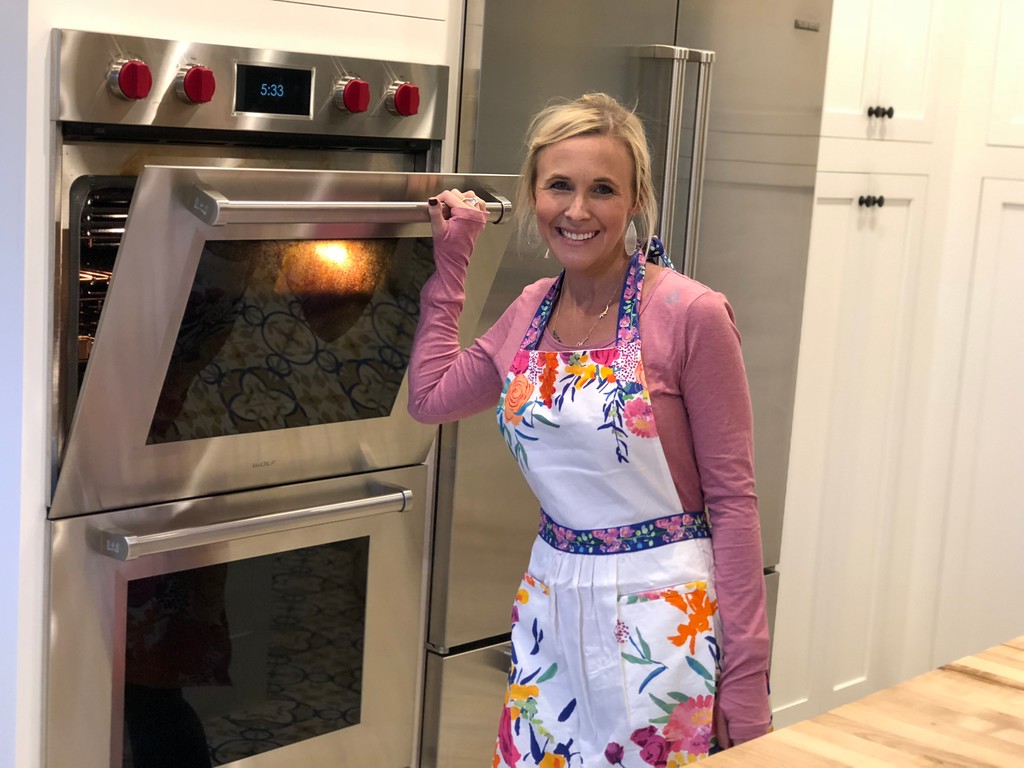 woman opening the oven in a kitchen