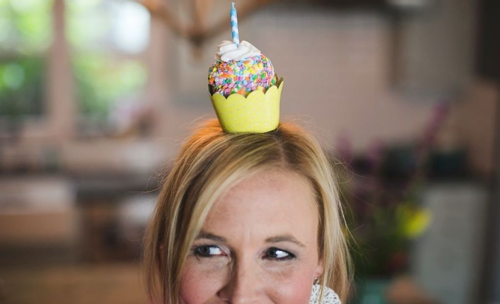 A woman with a cupcake on her head
