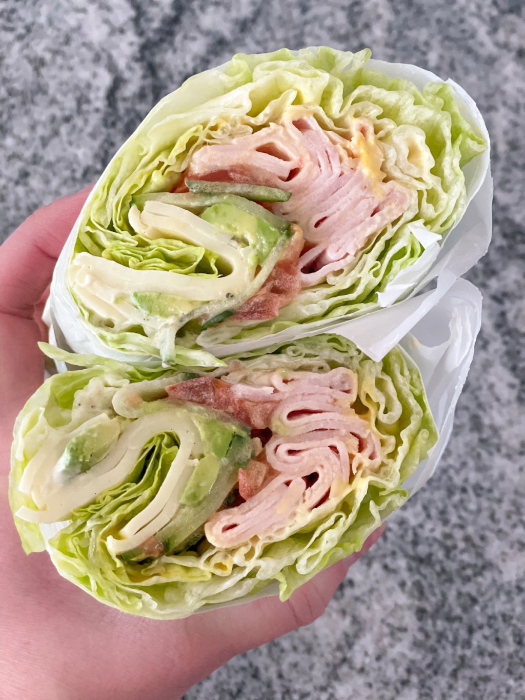 holding cut in half Jimmy John's unwich showing insides of the lettuce wrap