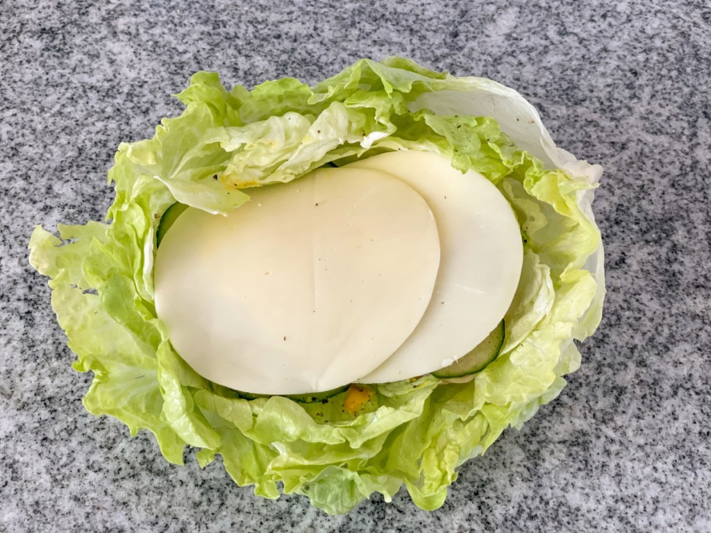 iceberg lettuce bowl filled to the top and topped with provolone slices