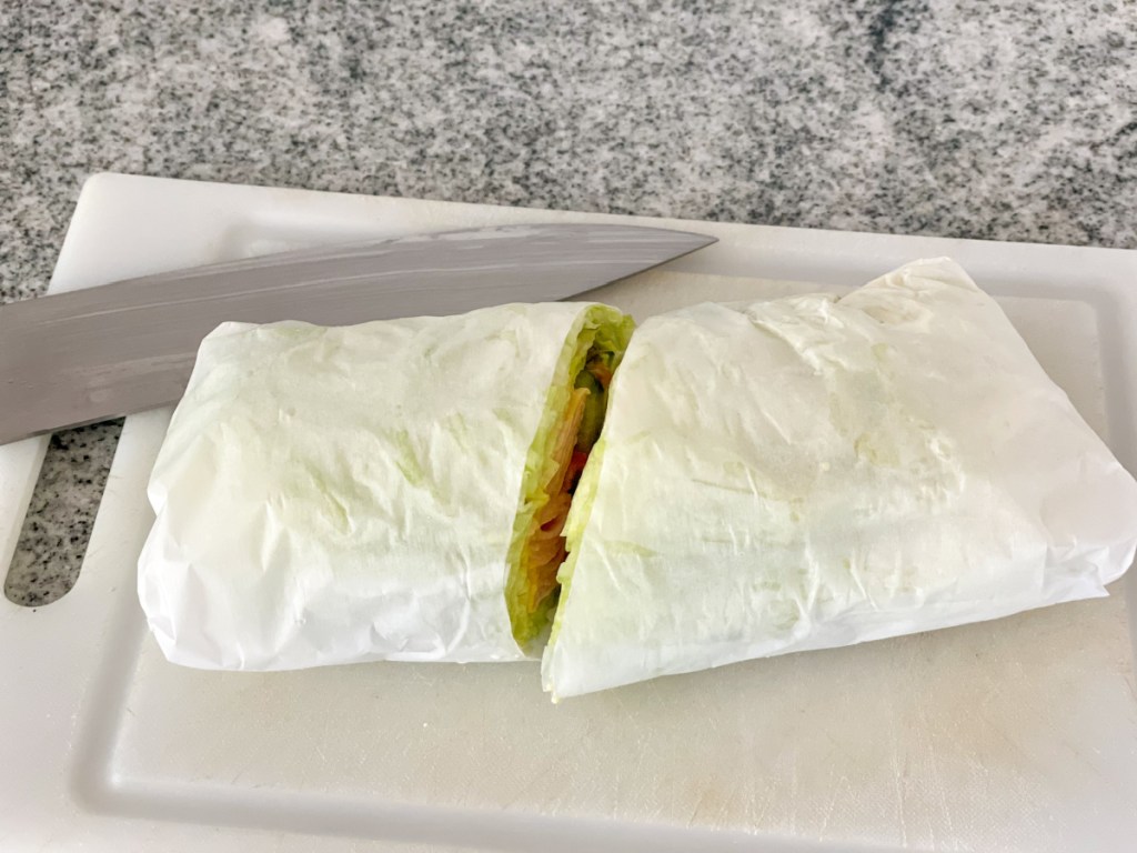Jimmy John's unwich rolled up in parchment paper and cut in half