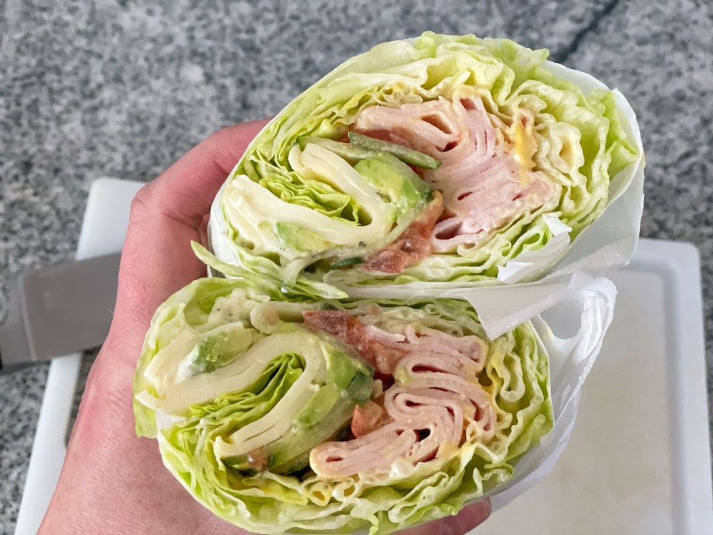 holding cut in half Jimmy John's unwich showing insides of the lettuce wrap