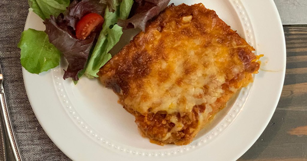 Cheesy Low-Carb Italian Sausage and Spaghetti Squash Casserole - a plate featuring Italian sausage and squash casserole with a green salad