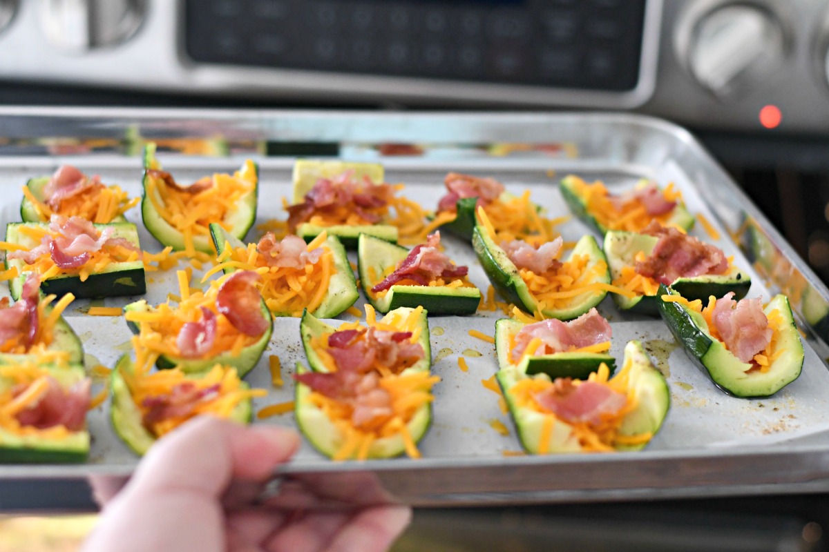 keto loaded zucchini skins recipe ready for a second baking, topped with cheese and bacon