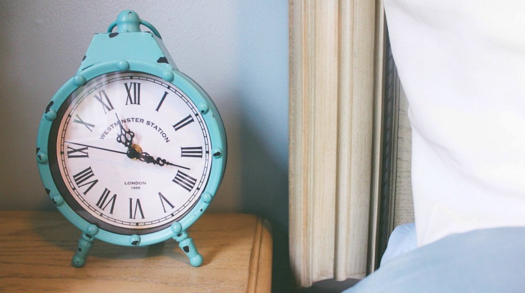 alarm clock on nightstand next to bed