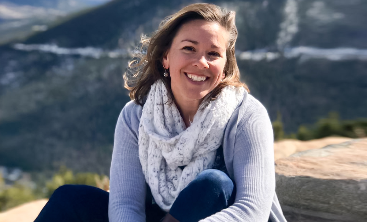 woman happy and smiling in front of scenic landscape