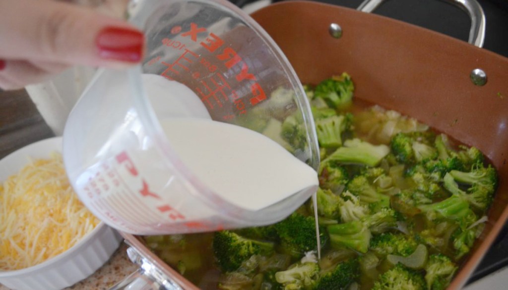 pouring cream into broccoli cheddar soup