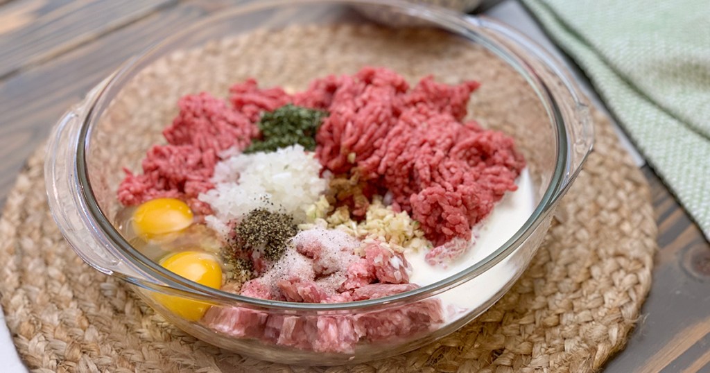 bowl with ground beef and other ingredients for meatballs