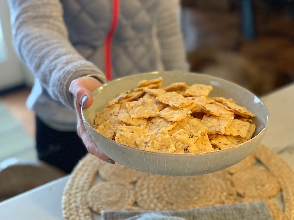 holding bowl of keto crackers 