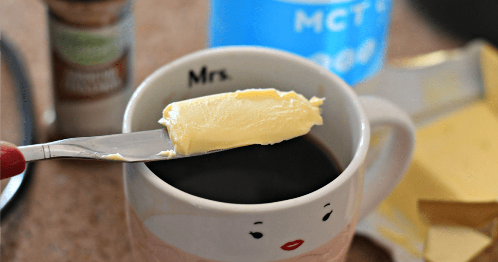 knife with butter and coffeen in mug 
