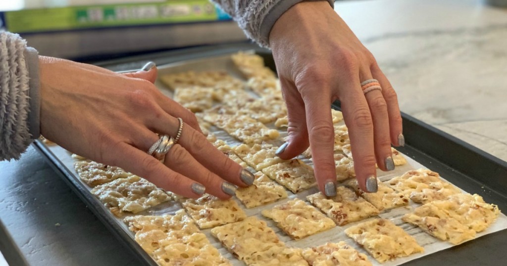 spreading keto low-carb crackers apart on pan with parchment paper