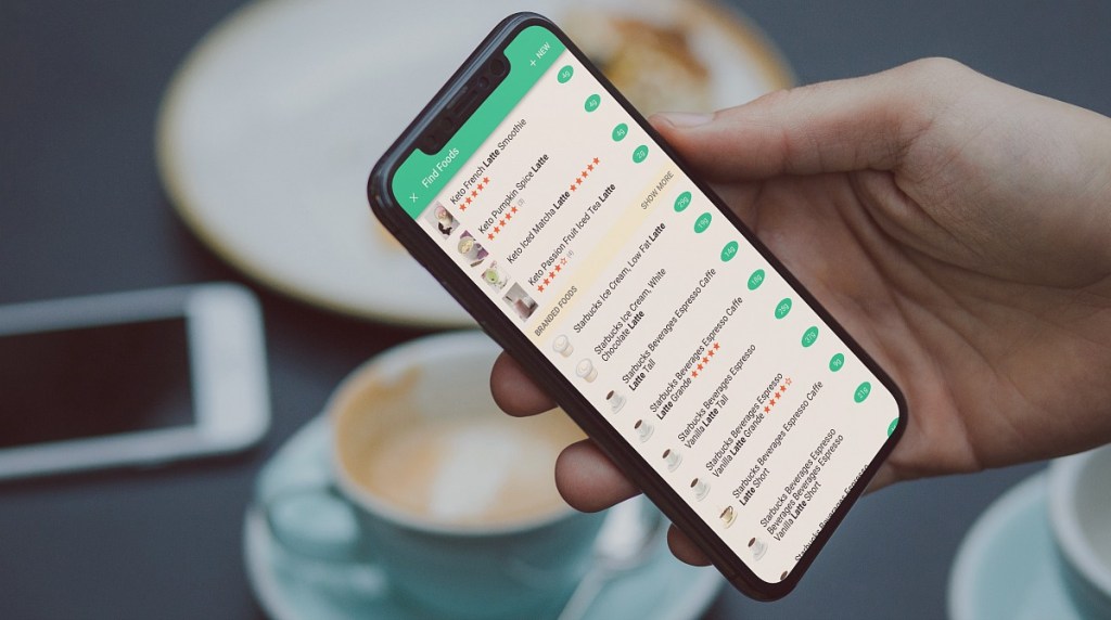 hand holding iphone with keto latte listings on carb manager