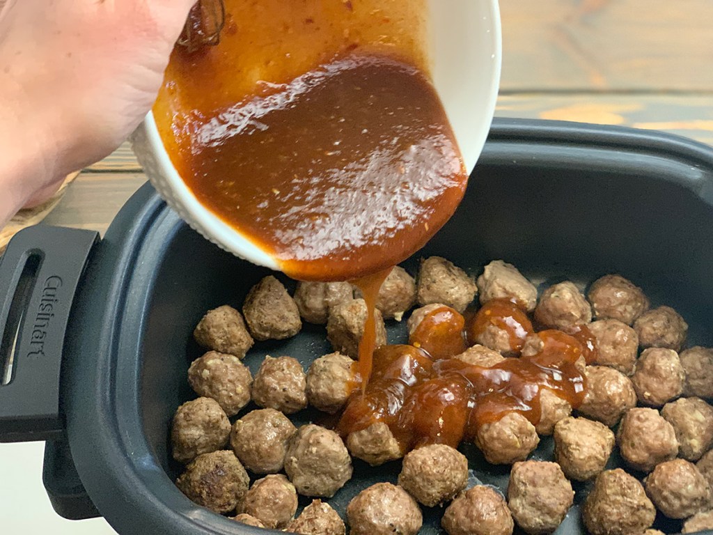 pouring apricot bbq sauce over meatballs