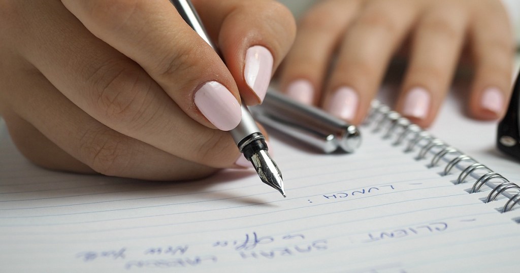 woman writing down lunch plans in notebook