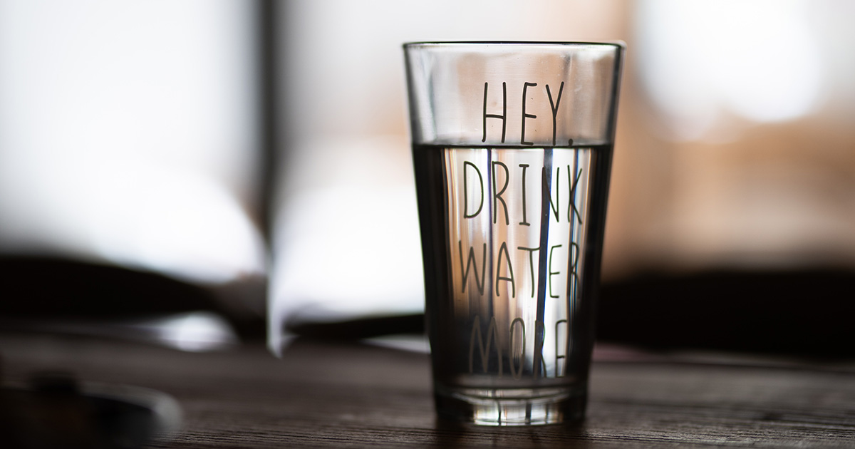 a glass of water that says Hey, Drink Water More