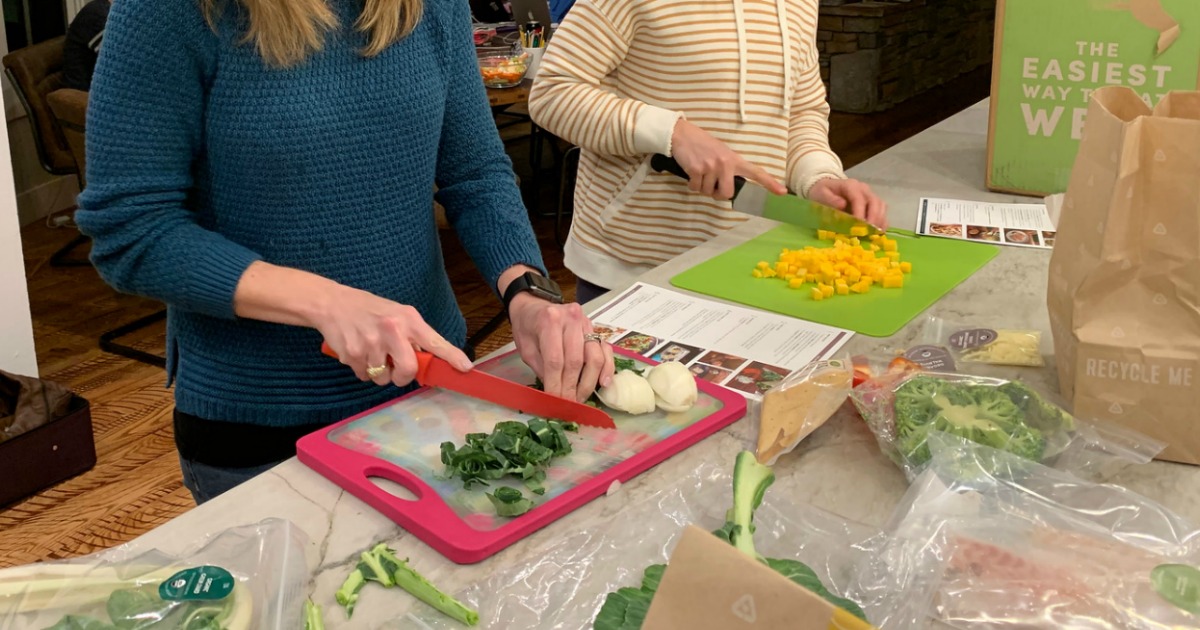 people chopping and preparing food in the kitchen