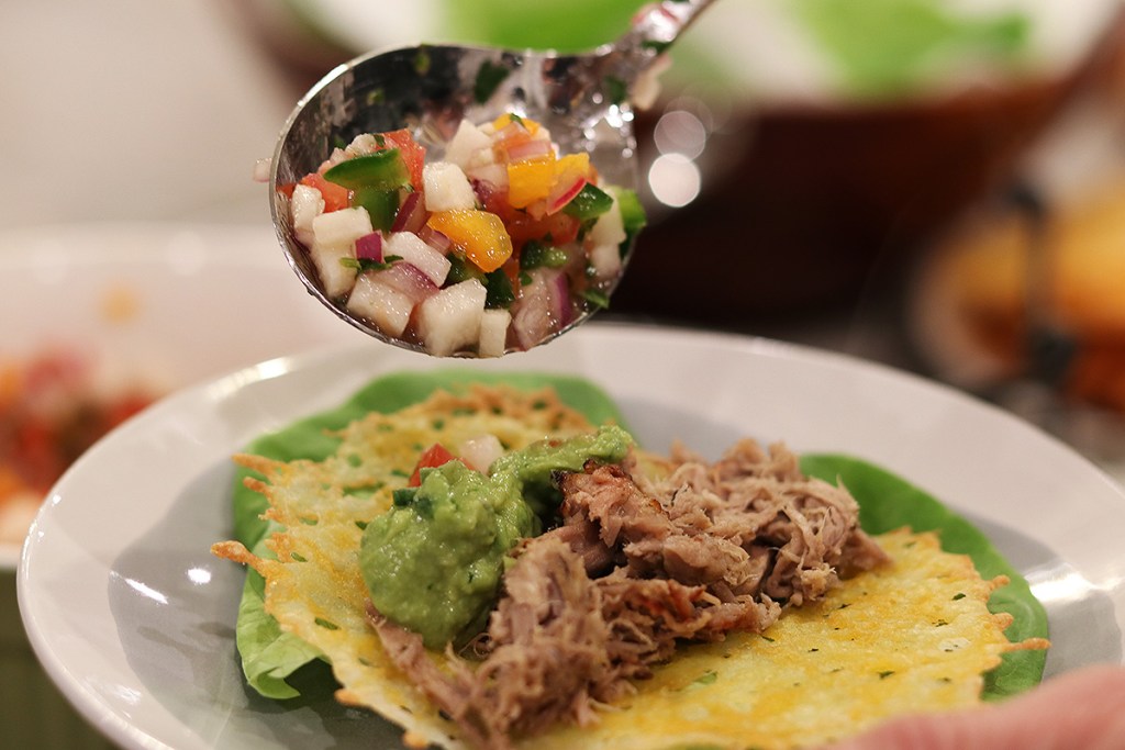 zesty keto jicama pico de gallo salsa recipe - a keto taco being topped with jicama pico de gallo