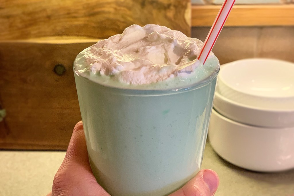 hand holding a large keto shamrock shake with whipped cream