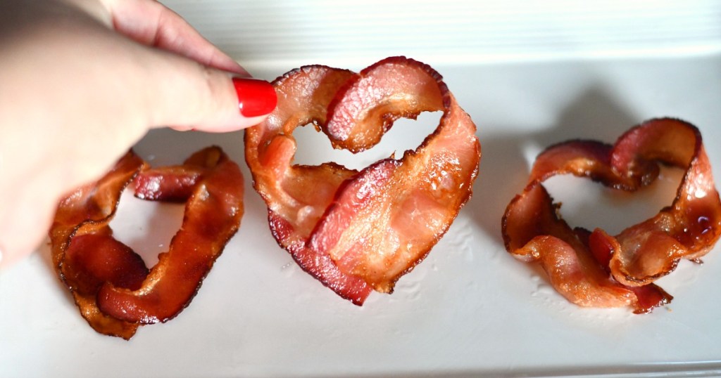 holding up heart shaped bacon hearts