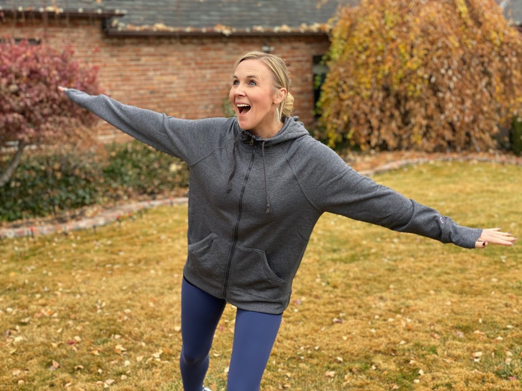 woman wearing workout gear with arms swinging out