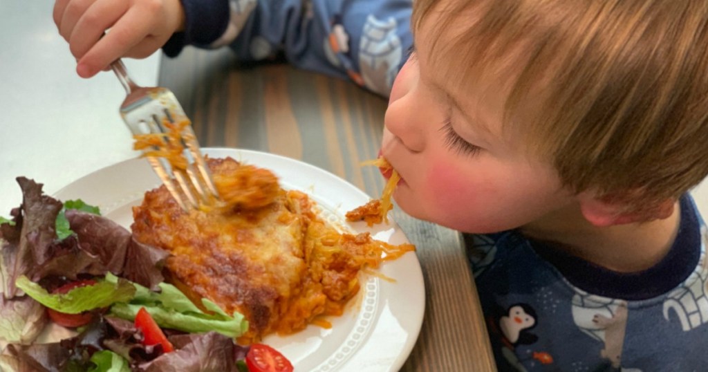 little boy eating keto casserole with salad
