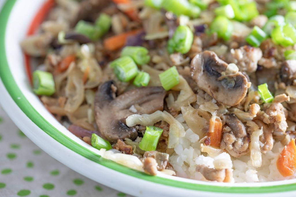 meat, cauliflower rice, mushrooms, and green onions in a bowl