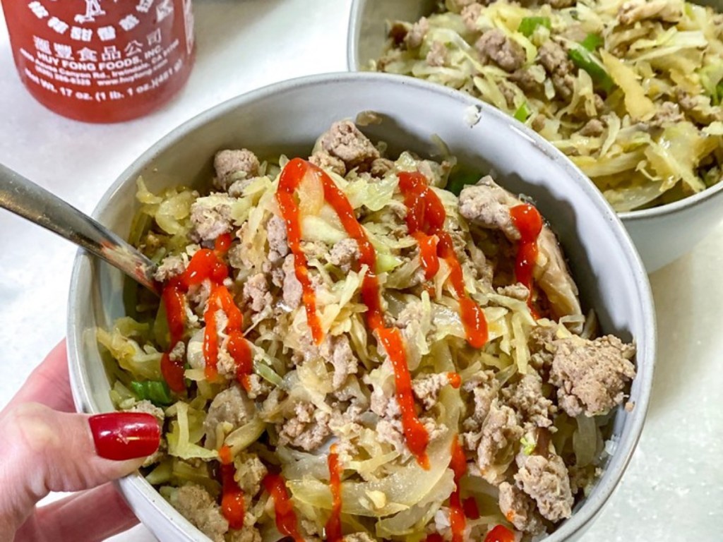 egg roll filling in bowl drizzled with sriracha sauce