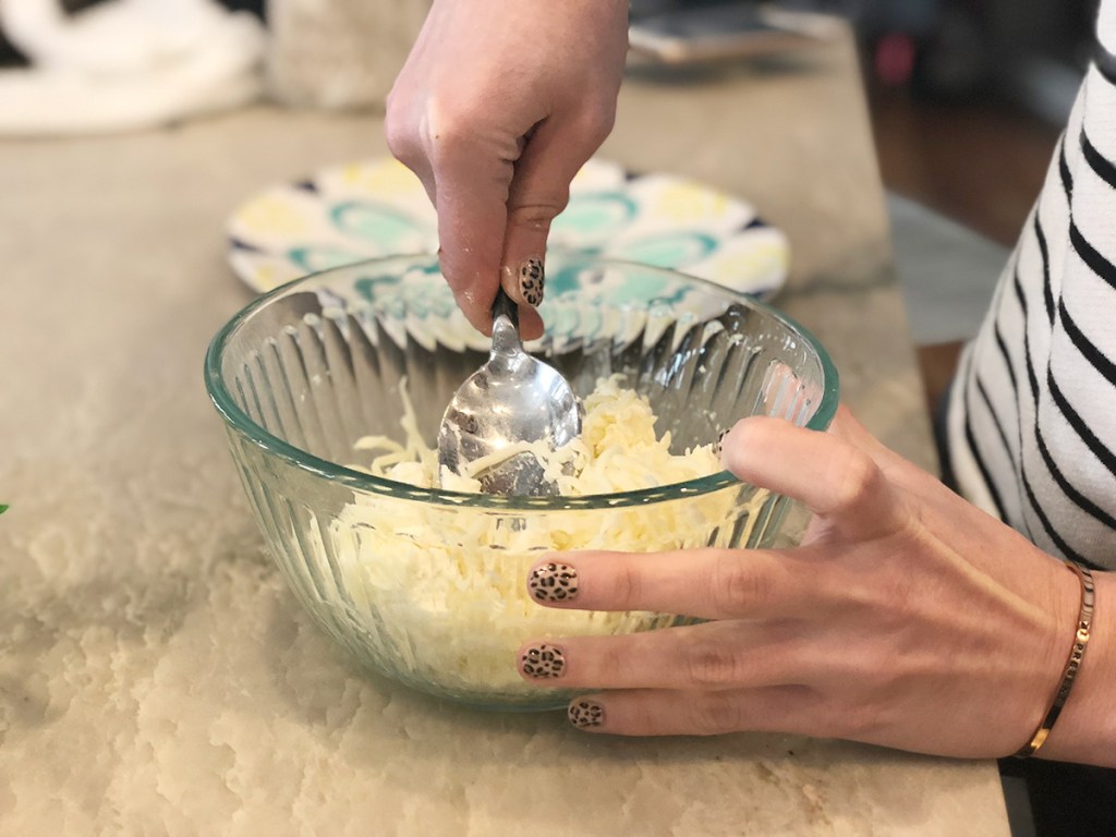 mixing together cream cheese and shredded mozzarella