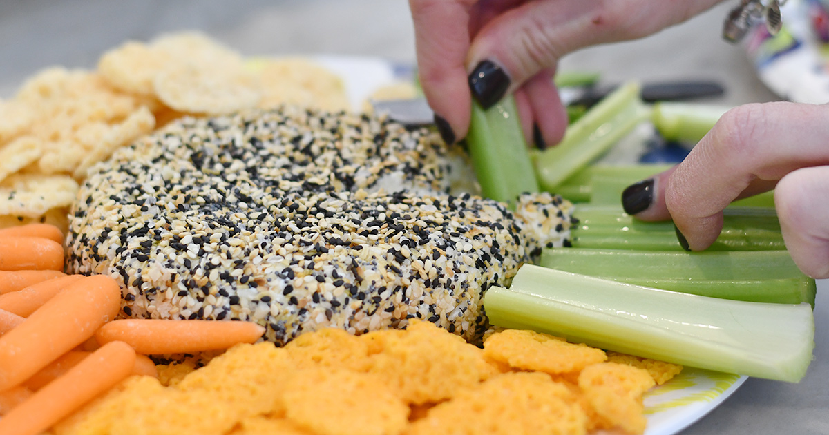 celery dipping into everything but the bagel cheese ball