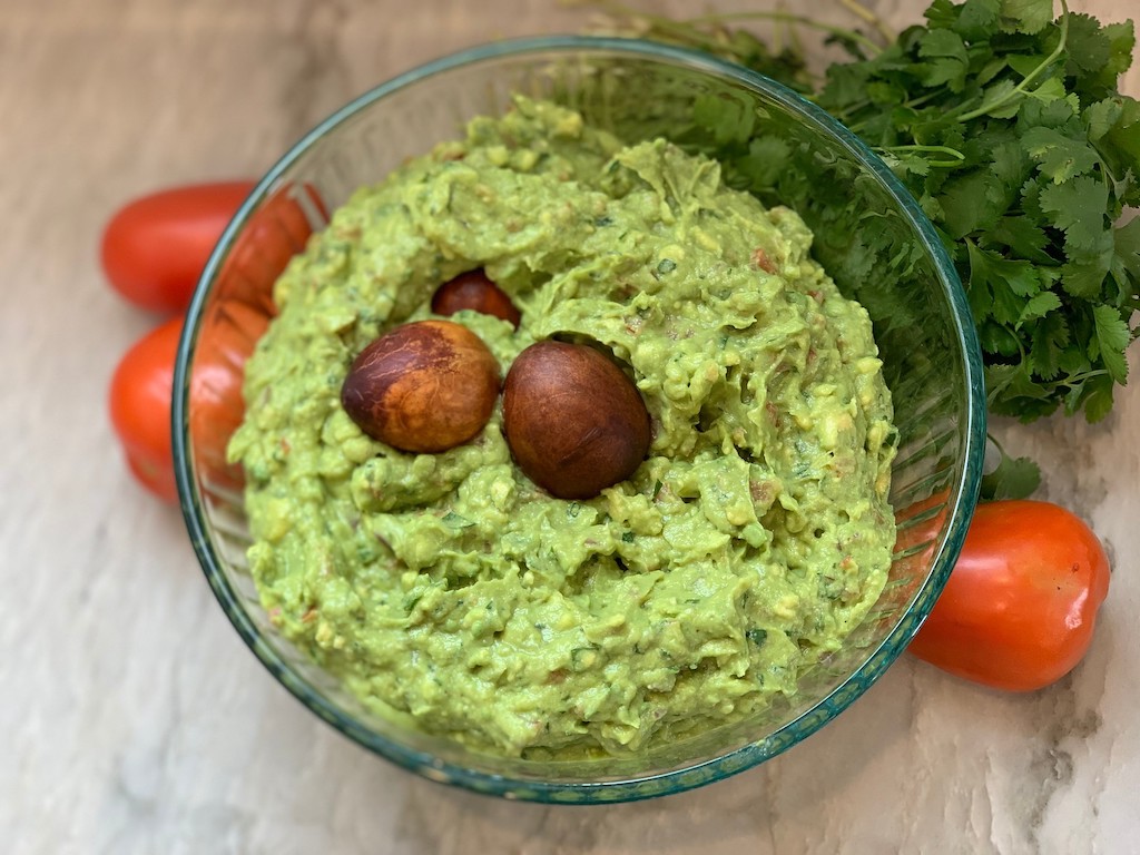 freshly prepared guacamole in large glass bowl