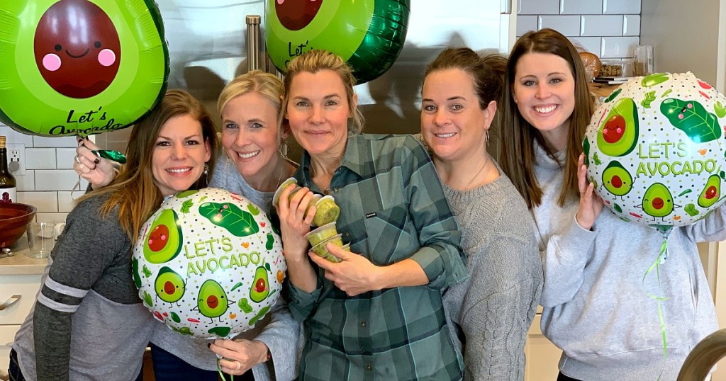 group of women holding avocado balloons