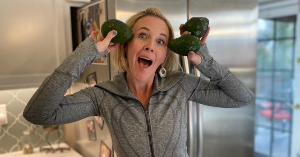 woman holding avocados in hands with mouth open 