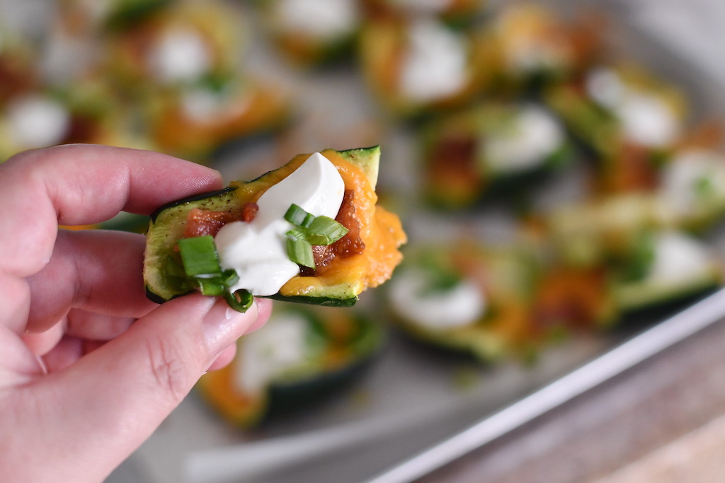 holding loaded keto zucchini skin 