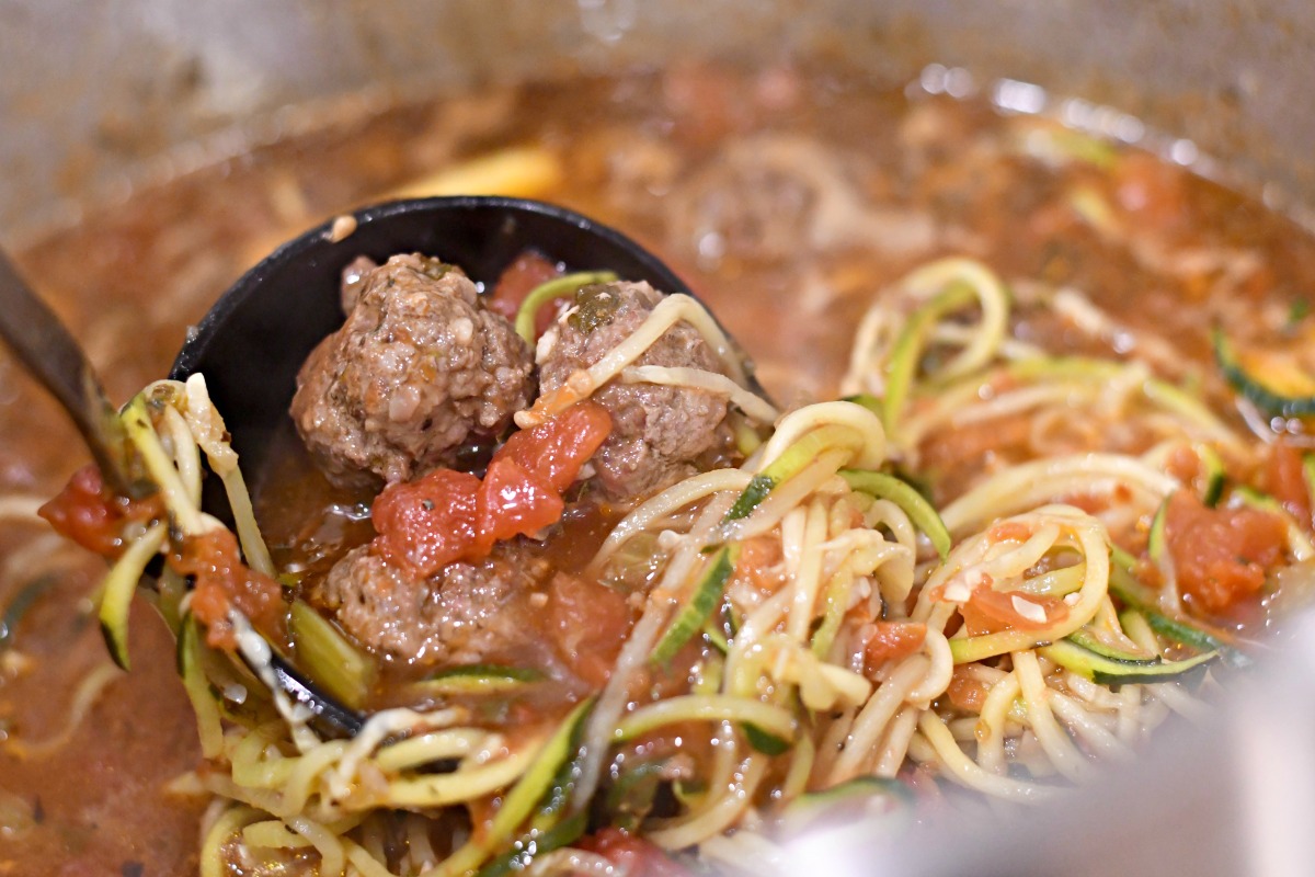 keto meatball soup on the stove in a ladle