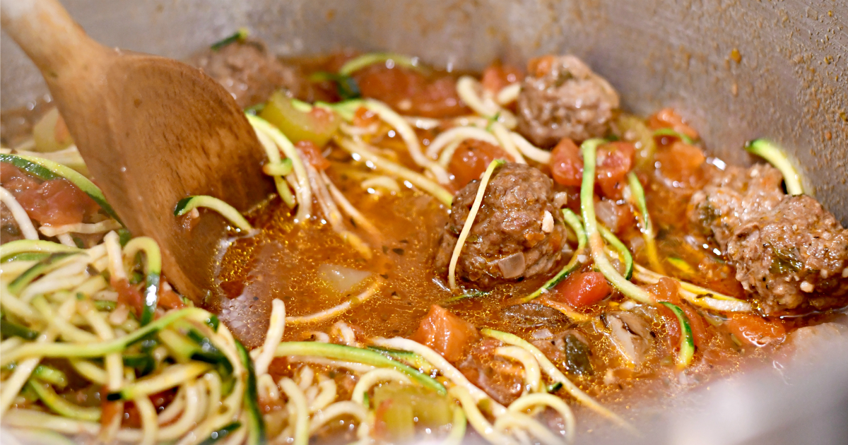 A large pot of keto meatball soup cooking on a stove