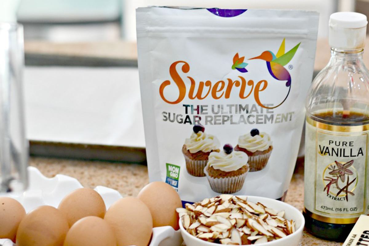 A bag of Swerve Confectioners sugar replacement on a counter with eggs and almonds