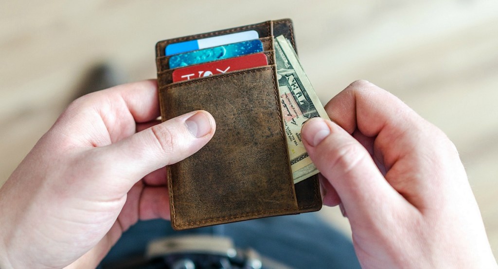 pulling cash out of wallet with bills and credit cards