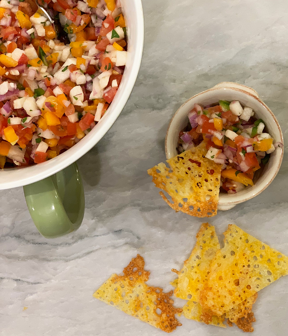 a small ramekin of pico de gallo next to a larger serving bowl