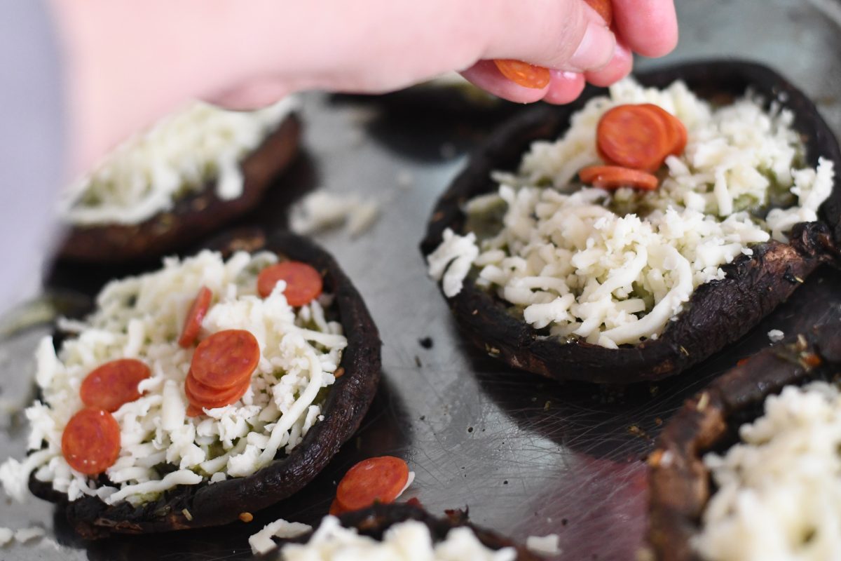 adding toppings to the portobello pizzas 