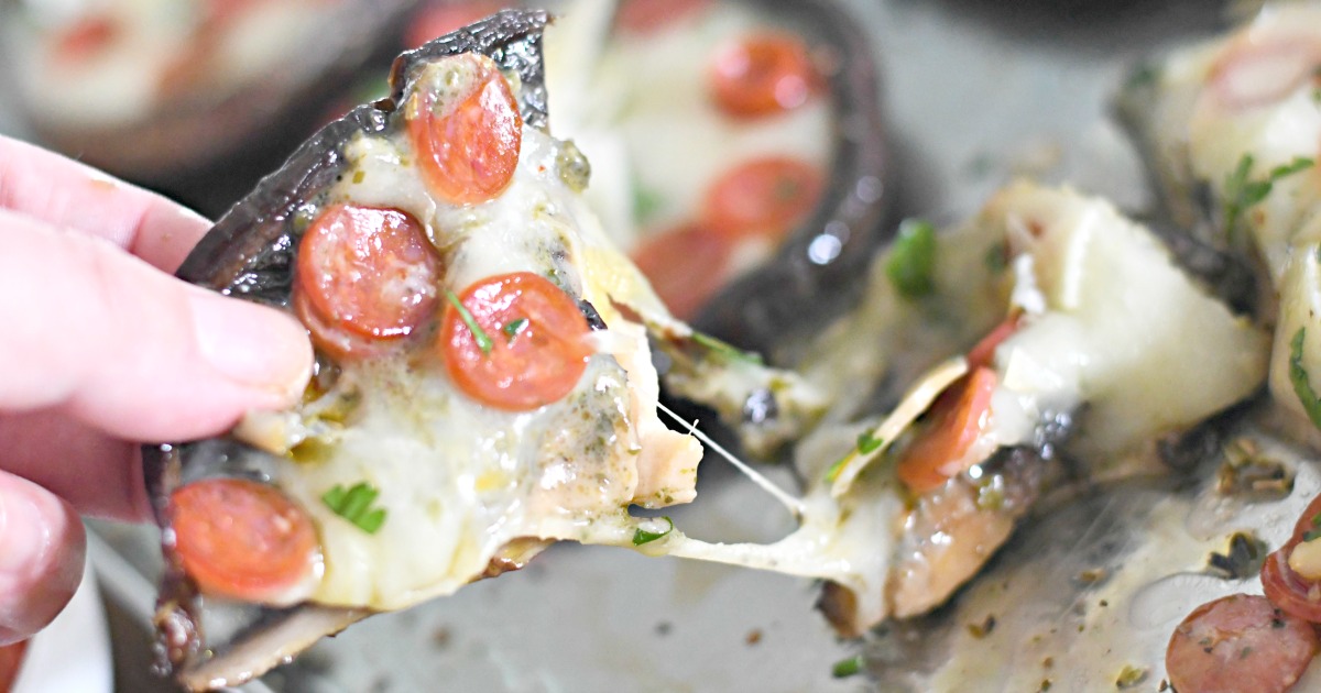 pulling a slice from a cheesy portobello mushroom pizza 