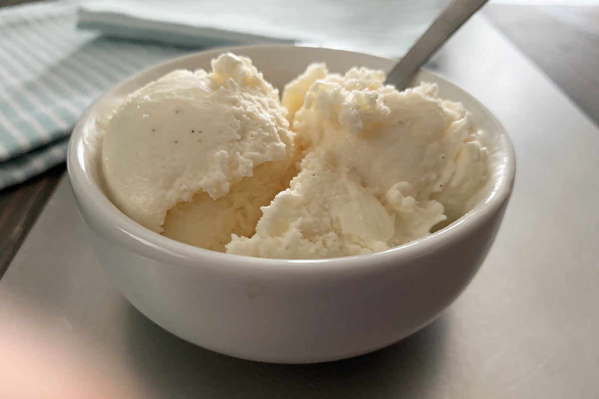 Low-Carb Vanilla Bean Ice Cream Recipe - a bowl with a spoon and two scoops of homemade ice cream