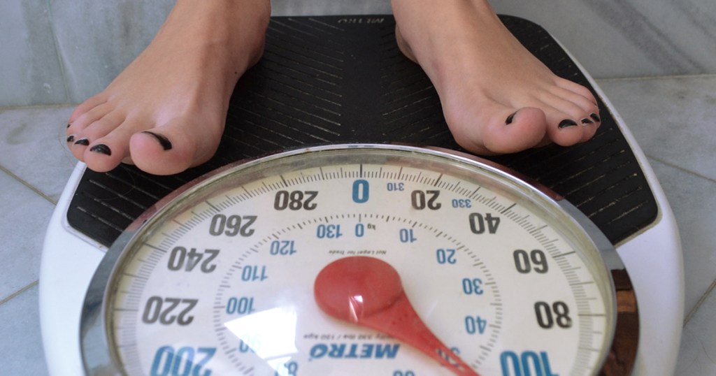 perte de poids sur une femme céto debout sur une balance