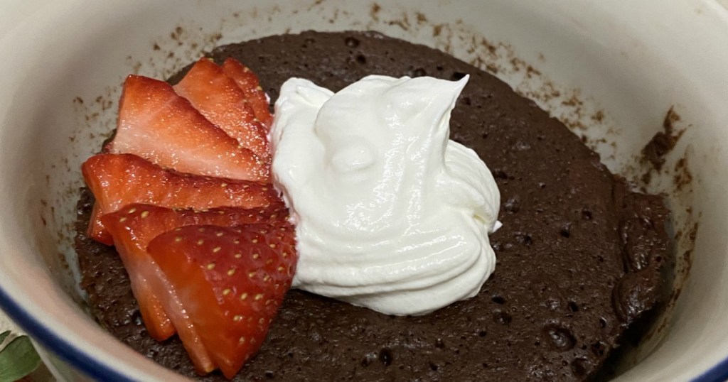 keto chocolate mug cake with strawberries and whipped cream