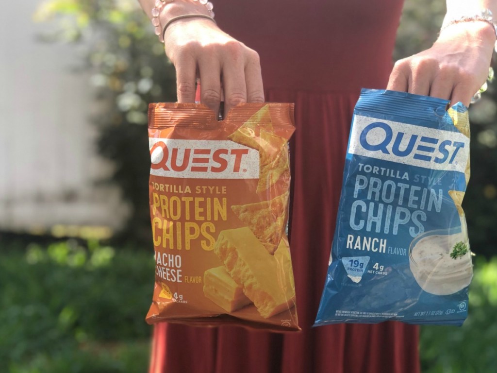 woman holding two bags of Quest tortilla style protein chips 