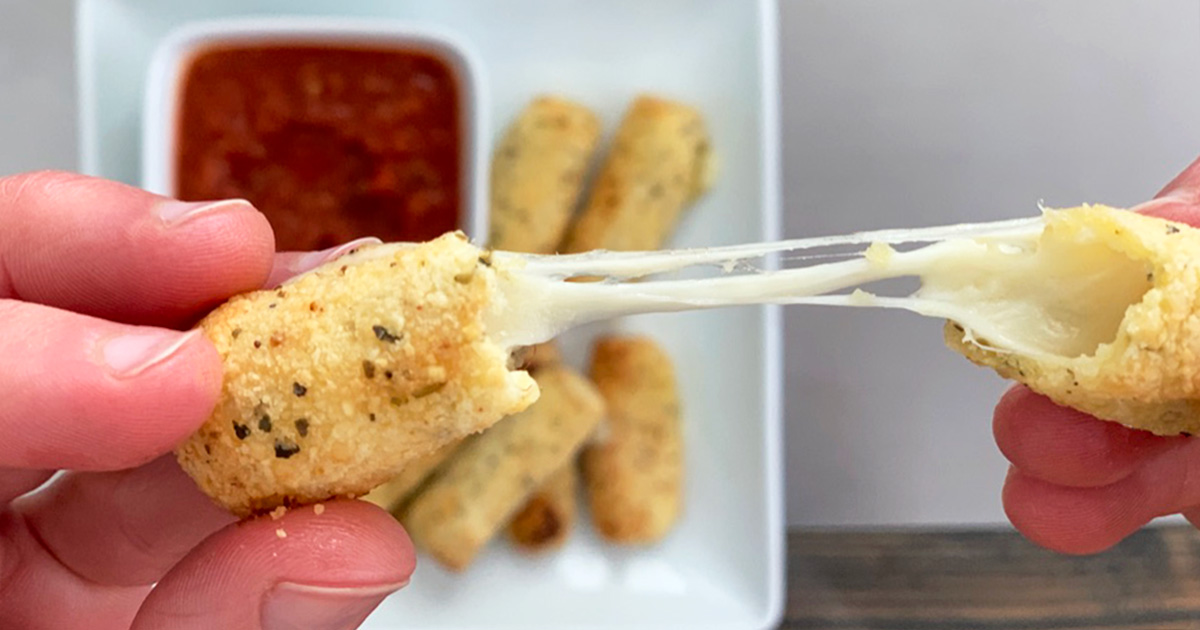 A cheese stick being torn open to expose strands of melted cheese