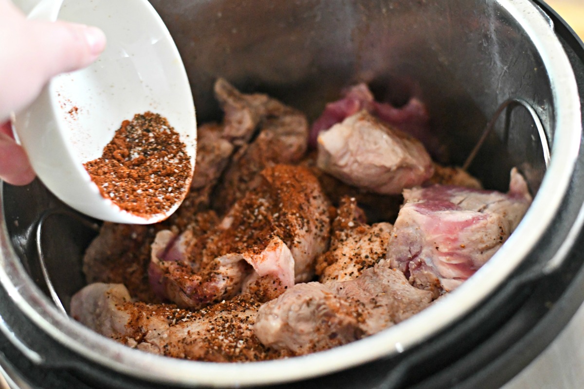 adding spices to the meat in the instant pot