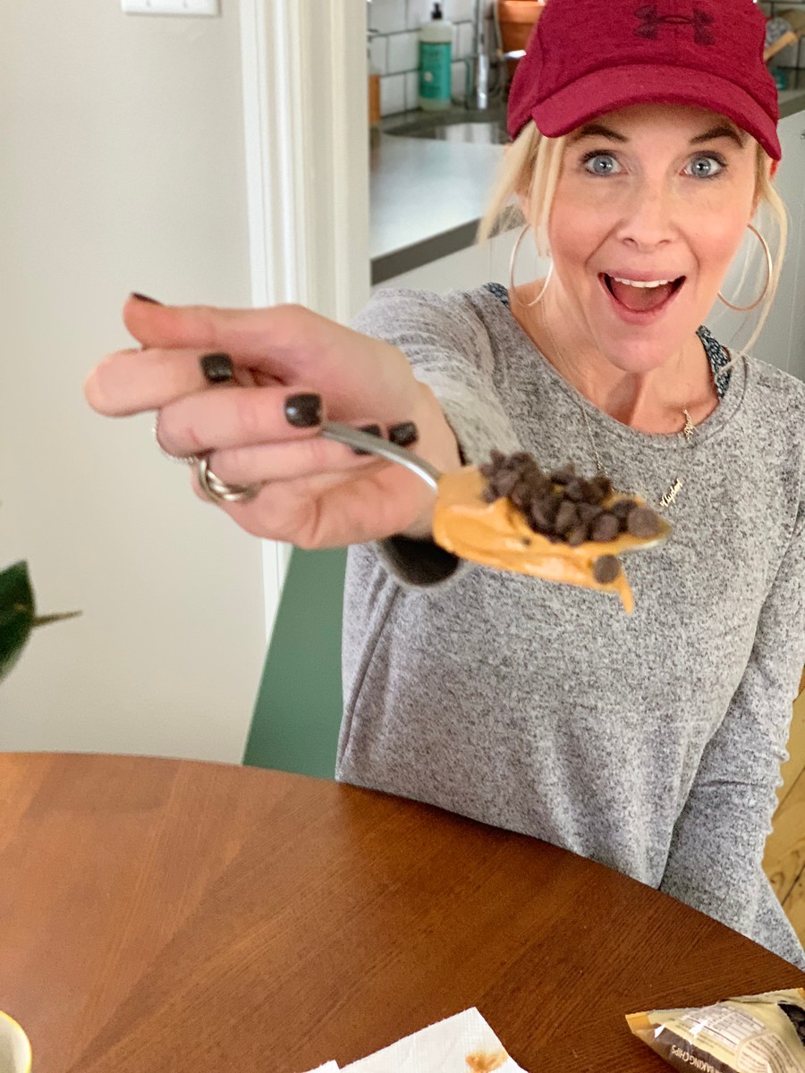 Collin holding peanut butter on a spoon with low carb chocolate chips 