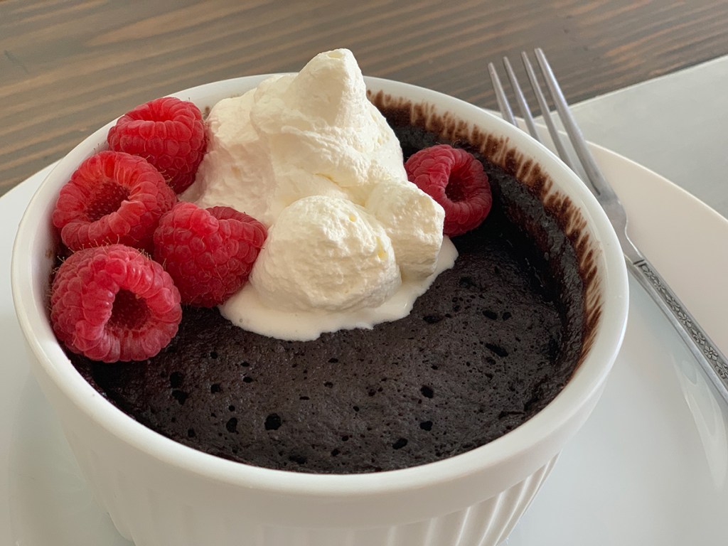 chocolate mug cake with whipped cream and berries