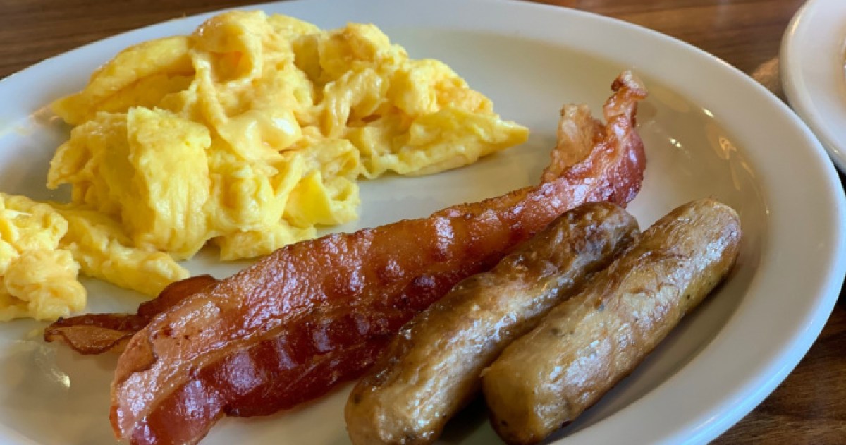 scrambled eggs, bacon, and sausage on white plate