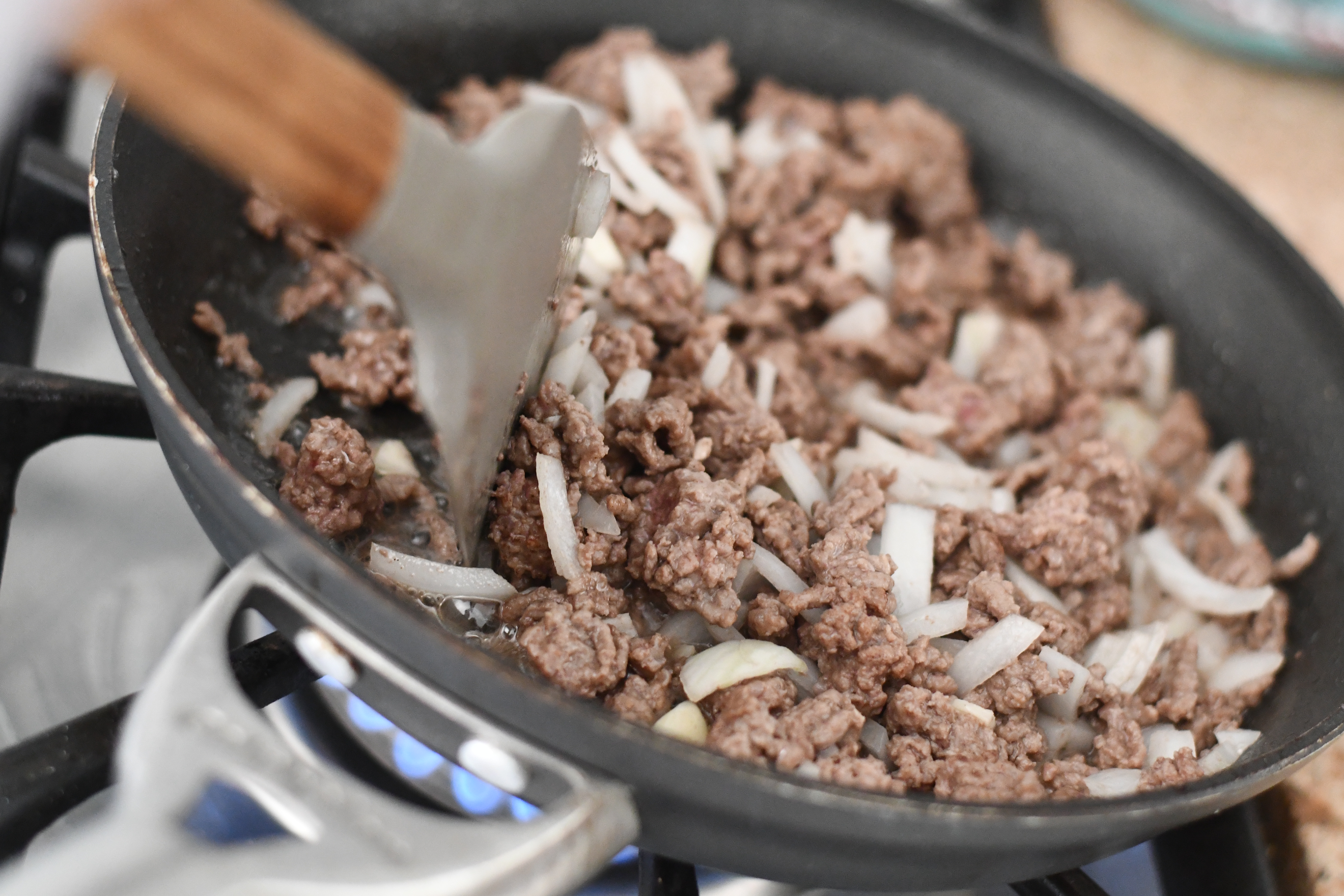cooking up the hamburger and onions in a pan